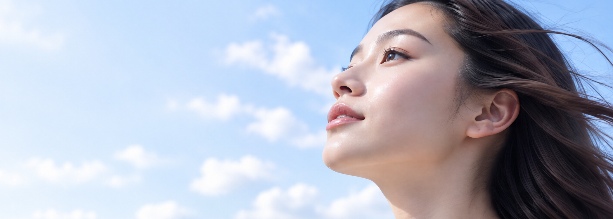 青空を背景に未来を見つめる女性